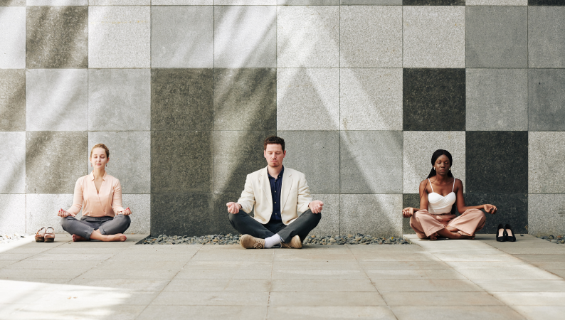 Grupa osób medytujących na tle kamiennej ściany – idealna ilustracja do tematu „cordyceps i medytacja” jako naturalnego wsparcia energii i koncentracji.