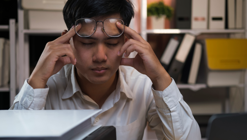 Mężczyzna z zamkniętymi oczami i okularami na czole, próbujący się skupić – Lion’s Mane na koncentrację jako naturalne wsparcie.