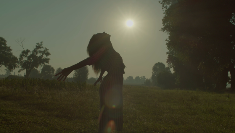 Kobieta rozciągająca się o wschodzie słońca na tle natury – symbol wewnętrznej siły i równowagi, jaką wspiera Cordyceps dla kobiet.