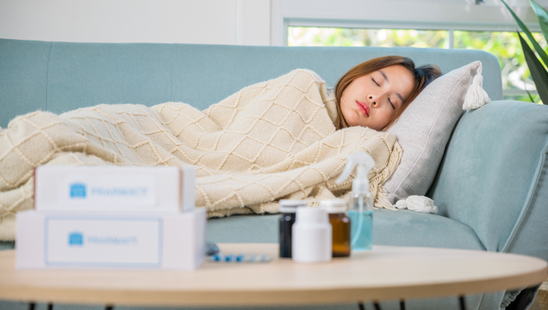 Kobieta śpiąca pod kocem na kanapie w czasie przeziębienia – naturalne wsparcie, takie jak grzyby lecznicze na odporność, może pomóc w regeneracji.