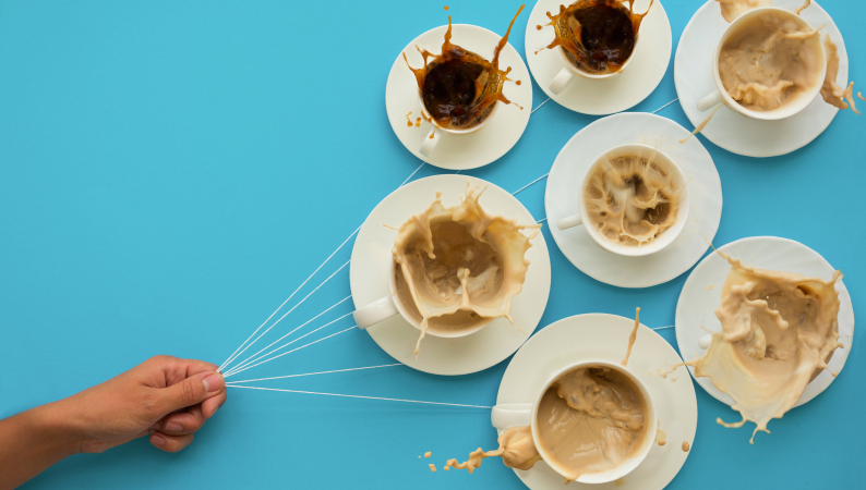 Wypalenie kofeinowe zilustrowane jako filiżanki kawy unoszone przez rękę, symbolizujące nadmiar kofeiny i jej wpływ na organizm