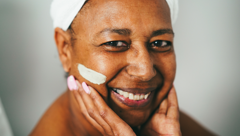 Chaga i skóra – naturalne wsparcie przeciwstarzeniowe, uśmiechnięta kobieta z maseczką pielęgnacyjną dbająca o zdrowie i młody wygląd skóry.