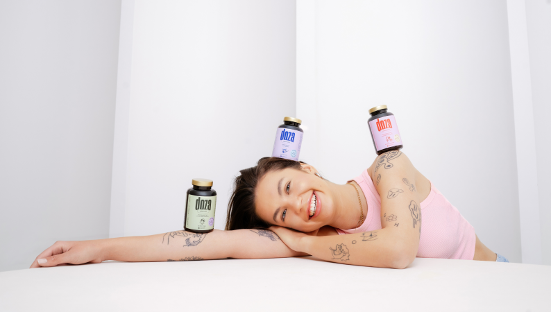 Suplementy Doza na energię i odporność – uśmiechnięta kobieta prezentuje naturalne produkty wspierające zdrowie i dobre samopoczucie.