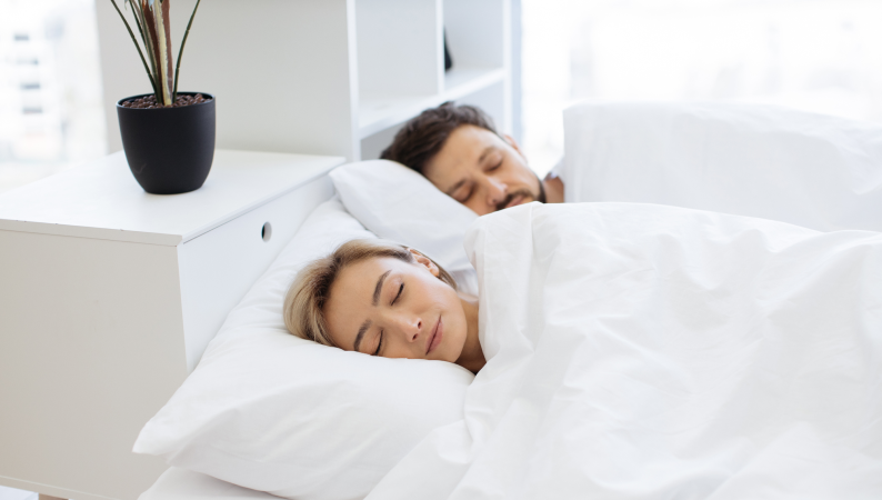 Para spokojnie śpiąca w łóżku – ilustracja tematu Ashwagandha a sen i naturalnego wsparcia dla głębokiego, regenerującego wypoczynku.